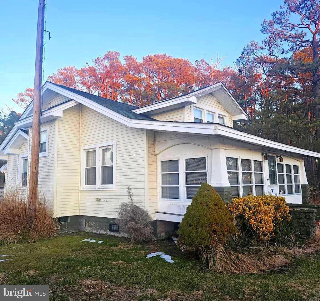 view of side of home featuring crawl space and a yard