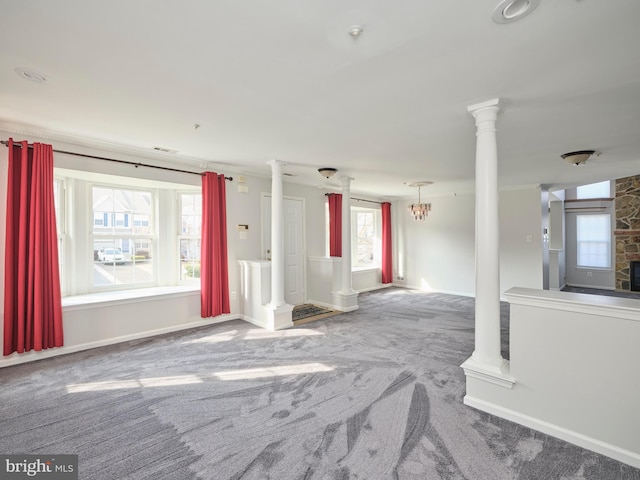 carpeted empty room featuring visible vents, baseboards, and decorative columns