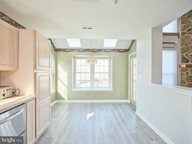 kitchen featuring visible vents, light wood-style flooring, light brown cabinetry, dishwasher, and lofted ceiling with skylight