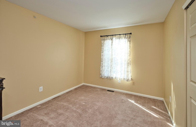 unfurnished room with visible vents, carpet floors, and baseboards