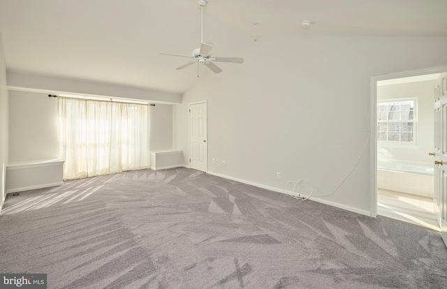 carpeted spare room featuring ceiling fan, high vaulted ceiling, and baseboards