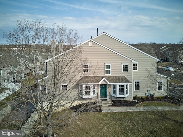 view of front of house with entry steps and a front lawn