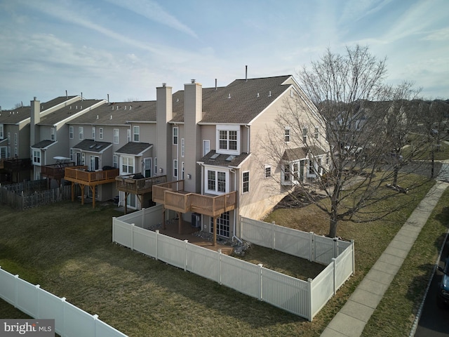 rear view of property featuring a residential view, a lawn, and a fenced backyard