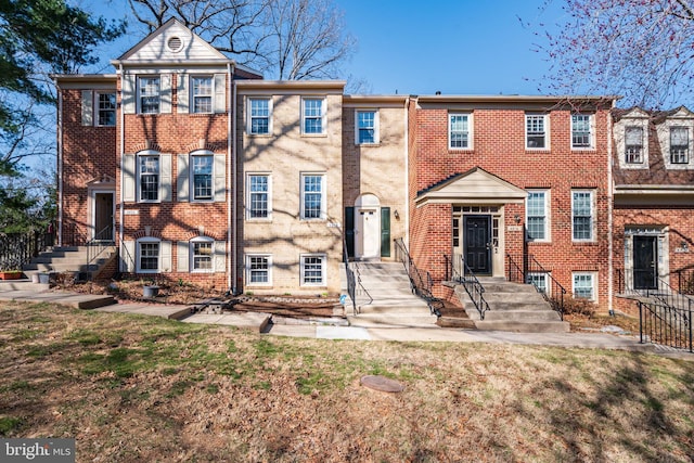 multi unit property featuring brick siding and a front yard