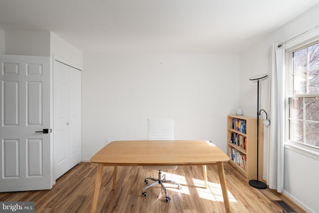 office area with visible vents, baseboards, and light wood-style floors