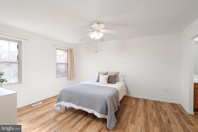 bedroom featuring light wood-type flooring, baseboards, visible vents, and a ceiling fan