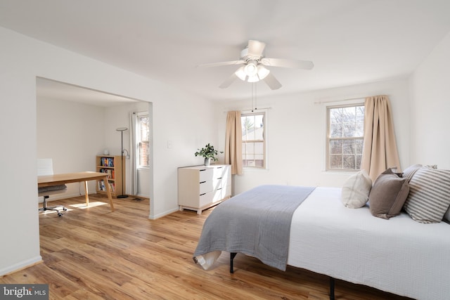 bedroom featuring light wood-style flooring, baseboards, and ceiling fan