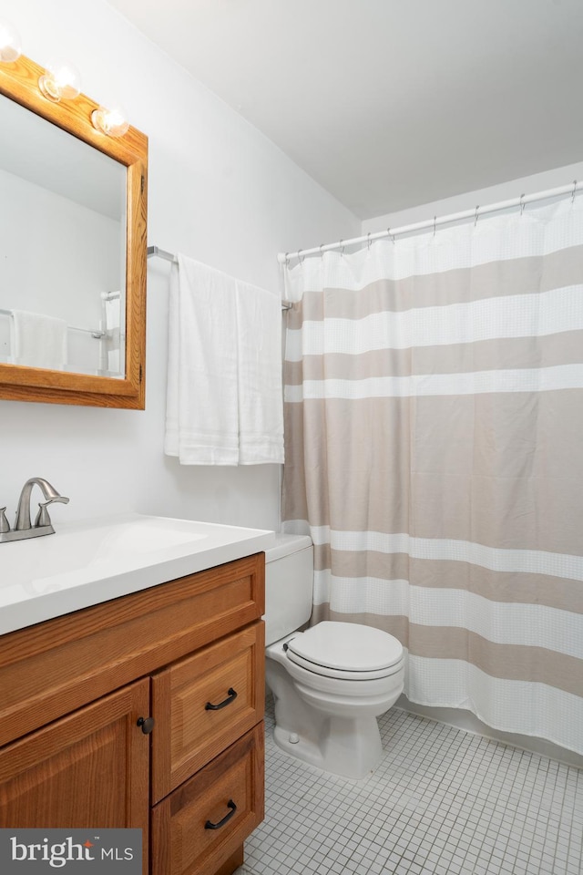 bathroom featuring tile patterned floors, curtained shower, toilet, and vanity