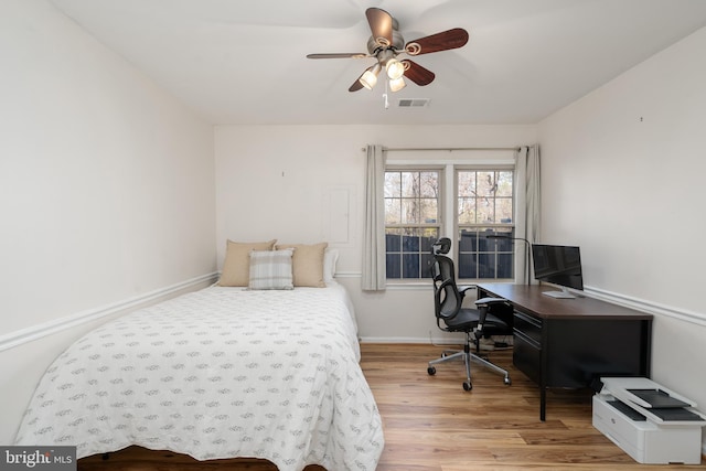 bedroom with visible vents, ceiling fan, baseboards, and wood finished floors