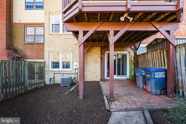 view of patio with central AC unit and fence