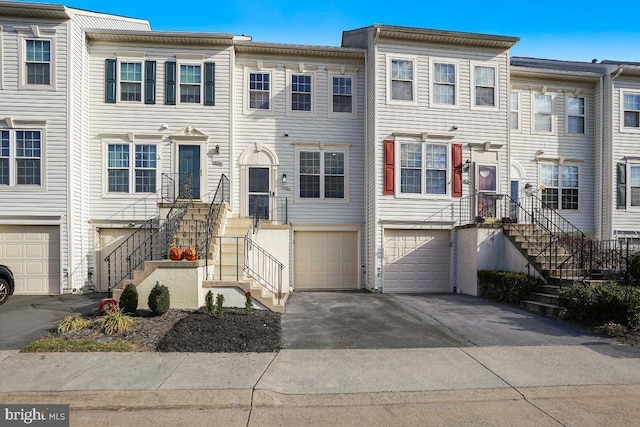 multi unit property featuring stairway, an attached garage, and driveway