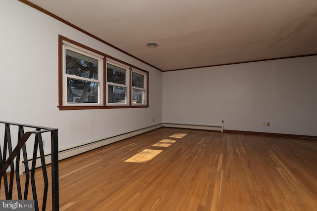 empty room with a baseboard heating unit, wood finished floors, baseboards, and ornamental molding