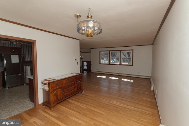 interior space featuring light wood finished floors, a notable chandelier, crown molding, and a baseboard heating unit