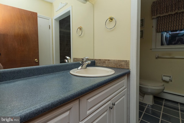 bathroom with tile patterned floors, toilet, vanity, and a baseboard radiator