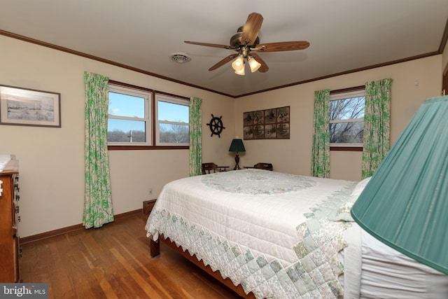 bedroom featuring wood finished floors, baseboards, visible vents, ceiling fan, and ornamental molding