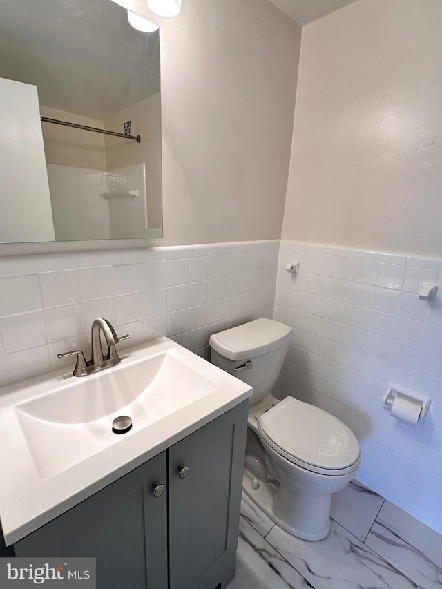 6621 Wakefield Dr Unit 403, Alexandria, VA 22307 - full bath with tile walls, toilet, vanity, marble finish floors, and a wainscoted wall