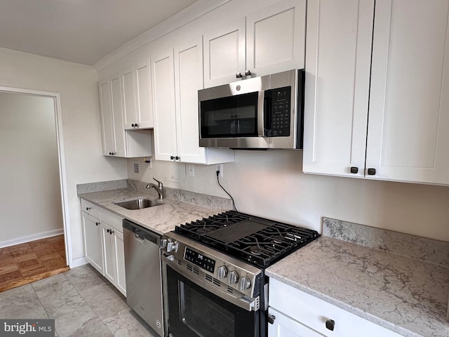 6621 Wakefield Dr Unit 403, Alexandria, VA 22307 - kitchen featuring appliances with stainless steel finishes, a sink, white cabinets, and baseboards