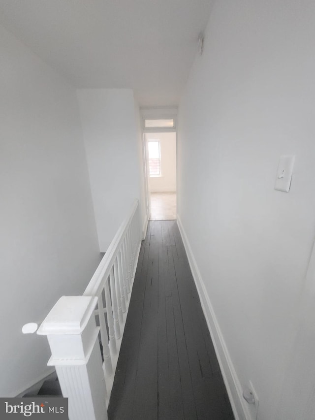 hallway with baseboards and dark wood-style floors