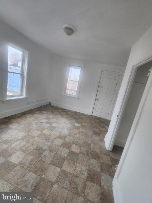 unfurnished room featuring baseboards