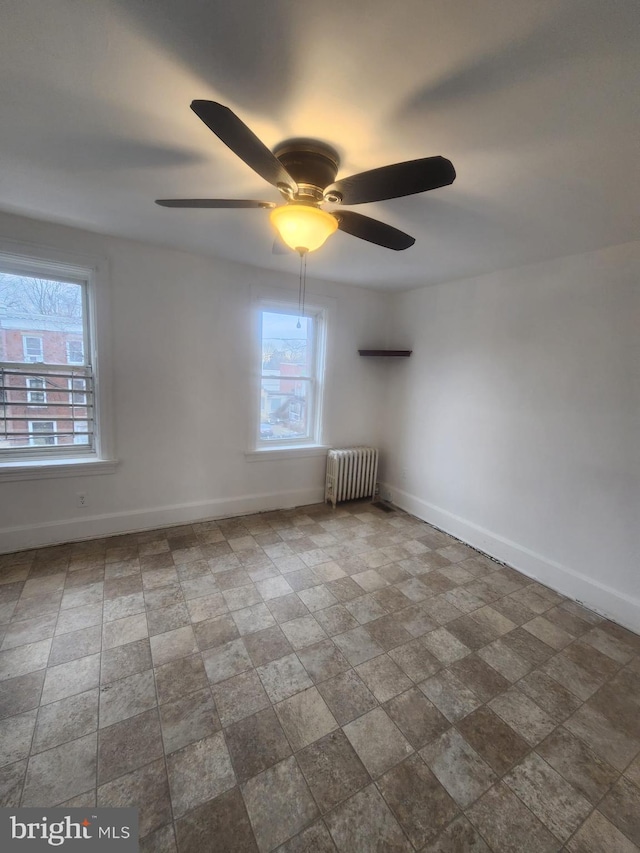 spare room with a wealth of natural light, radiator heating unit, and baseboards