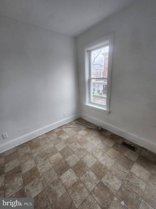 unfurnished room featuring baseboards and visible vents