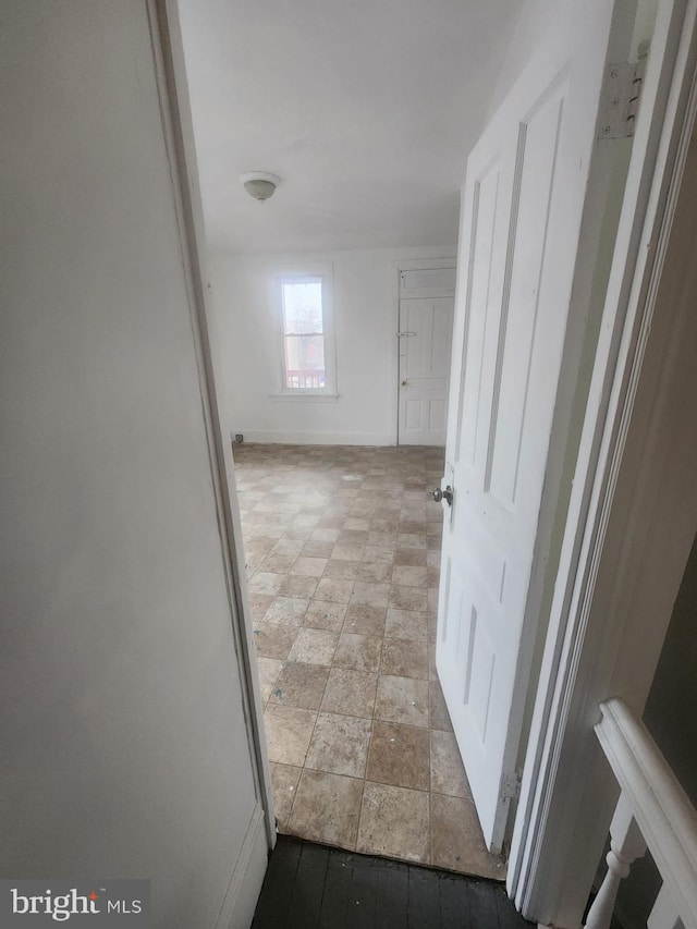 hall with stone finish flooring and baseboards