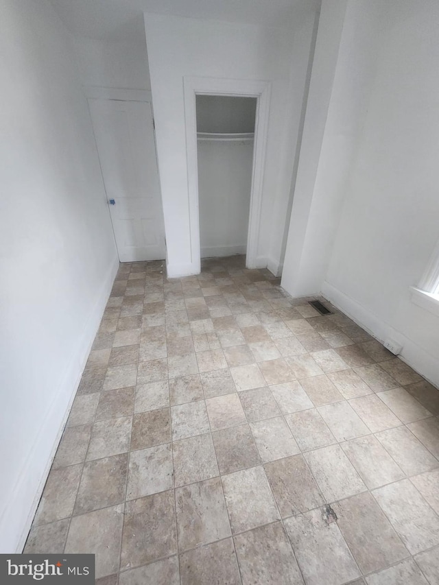 unfurnished bedroom with visible vents, a closet, and baseboards