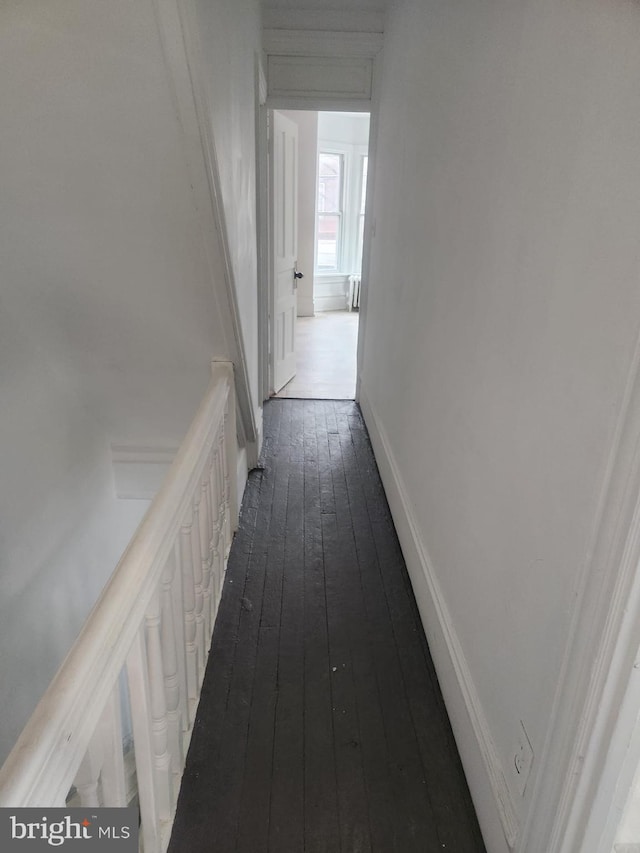 hall with baseboards and dark wood-style flooring