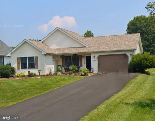 single story home with aphalt driveway, a garage, and a front yard