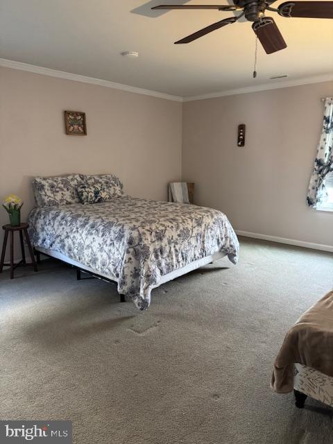 carpeted bedroom with baseboards, a ceiling fan, and crown molding