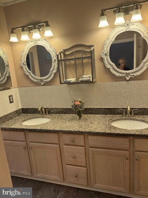 full bathroom featuring double vanity and a sink