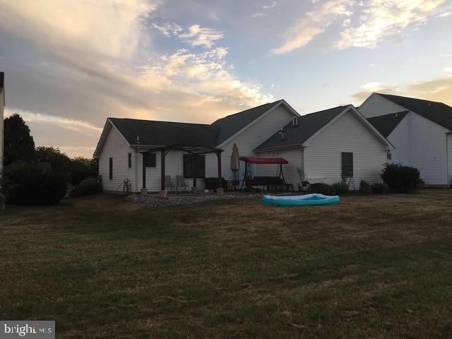 rear view of house with a patio and a yard