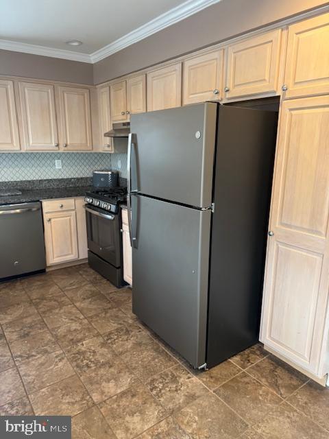 kitchen featuring ornamental molding, under cabinet range hood, appliances with stainless steel finishes, dark countertops, and backsplash