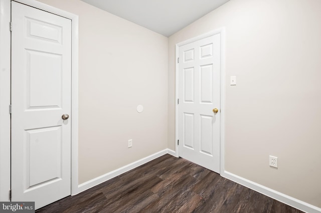 unfurnished bedroom featuring dark wood-type flooring and baseboards