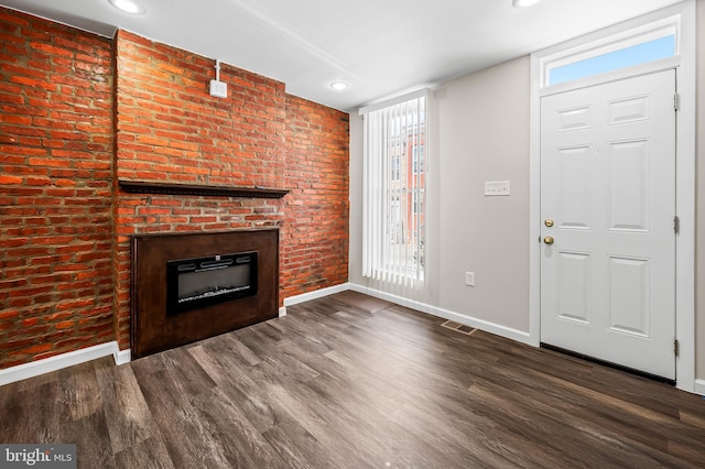 unfurnished living room with visible vents, wood finished floors, recessed lighting, baseboards, and a brick fireplace