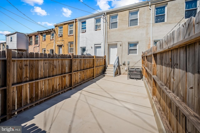 rear view of house featuring stucco siding, fence private yard, and entry steps