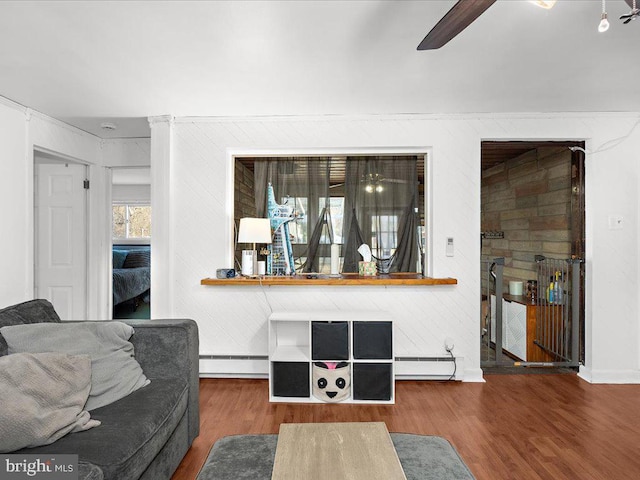 living room featuring baseboard heating, ceiling fan, and wood finished floors