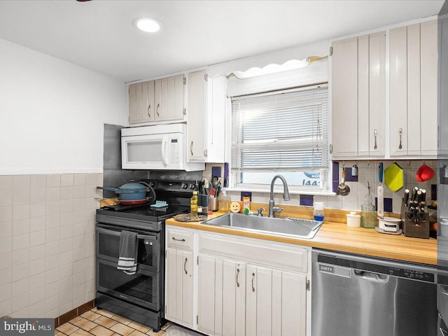 kitchen featuring a sink, stainless steel dishwasher, black range with electric cooktop, light countertops, and white microwave