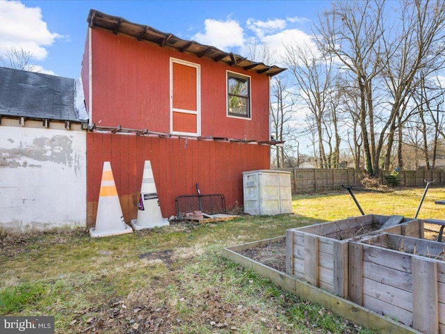 view of outbuilding with an outdoor structure, a vegetable garden, and fence