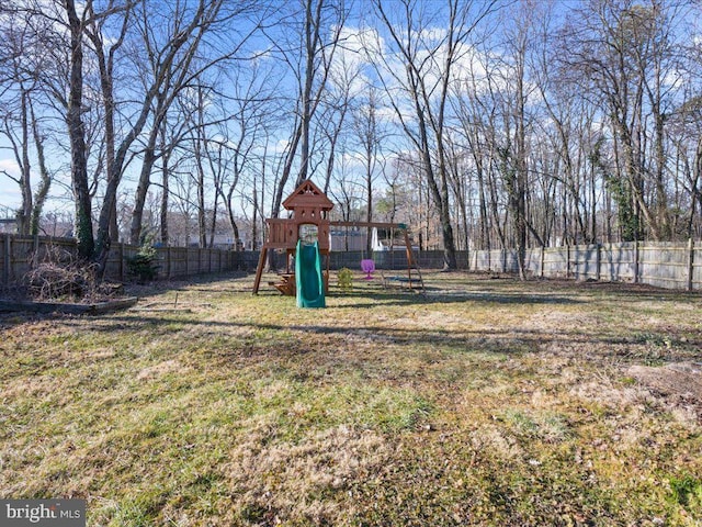 view of yard featuring a fenced backyard and playground community