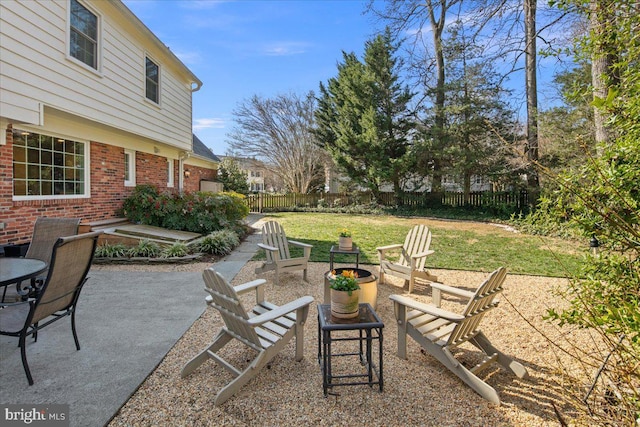 view of yard with fence, a fire pit, and a patio area