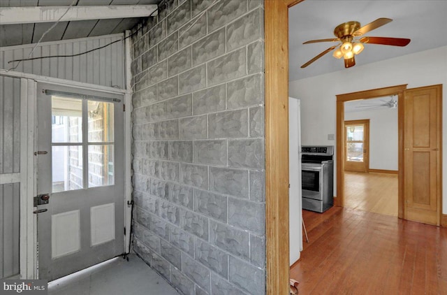 interior space with hardwood / wood-style floors, concrete block wall, and plenty of natural light