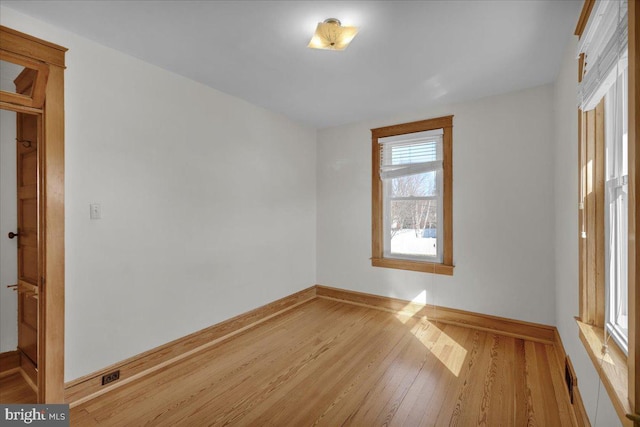 unfurnished room with baseboards and wood finished floors