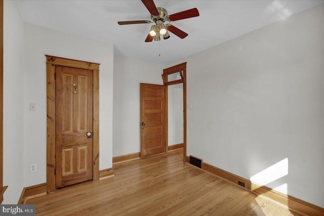 unfurnished bedroom with visible vents, light wood-style flooring, a ceiling fan, and baseboards