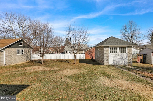 view of yard featuring a storage unit, an outdoor structure, and fence