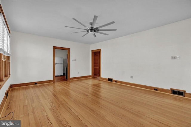 interior space featuring a ceiling fan, baseboards, visible vents, and light wood finished floors