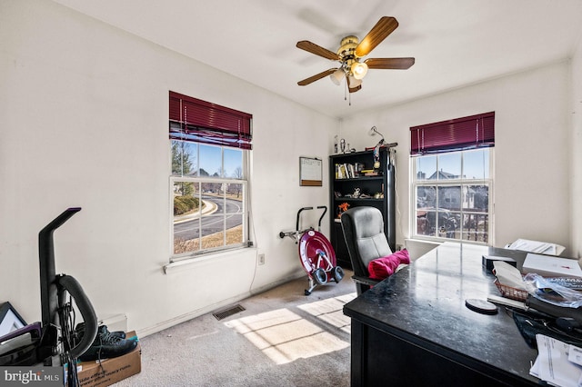 home office featuring visible vents, carpet floors, baseboards, and ceiling fan