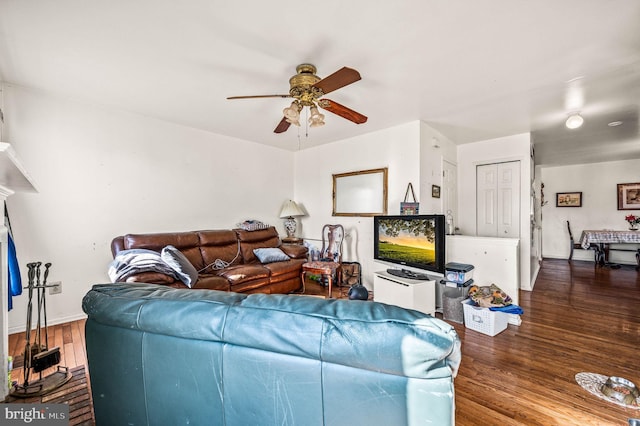 living area featuring a ceiling fan, wood finished floors, and baseboards