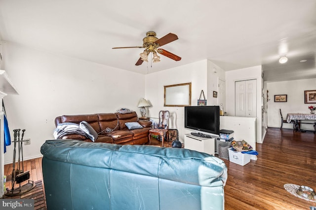 living area with wood finished floors, baseboards, and ceiling fan