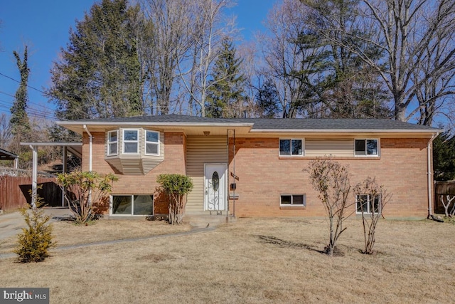 raised ranch with brick siding, a front lawn, and fence